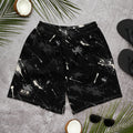 Front view of black athletic shorts with white and gray paint splatter and a small ATB logo, laid flat on a gray surface.