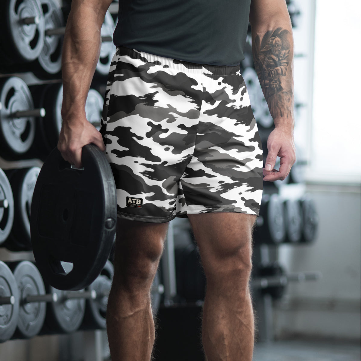 Man wearing white camouflage athletic shorts and a dark workout shirt in a gym.