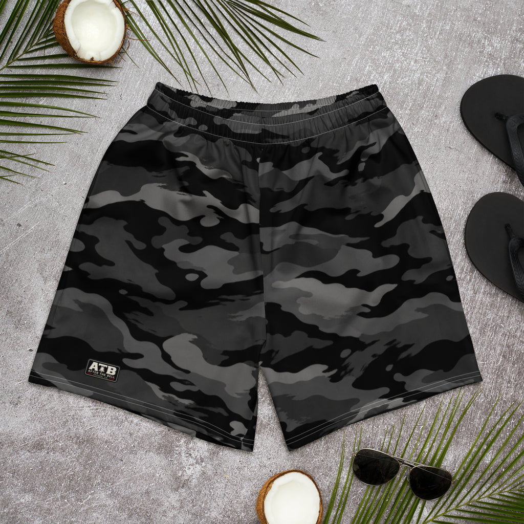 Front view of black, charcoal and black camouflage athletic shorts with a small ATB logo, laid flat on a gray surface.