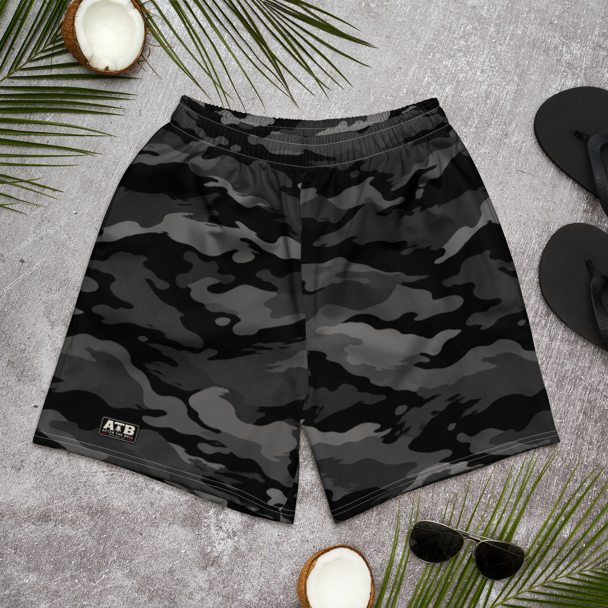 Front view of black, charcoal and black camouflage athletic shorts with a small ATB logo, laid flat on a gray surface.