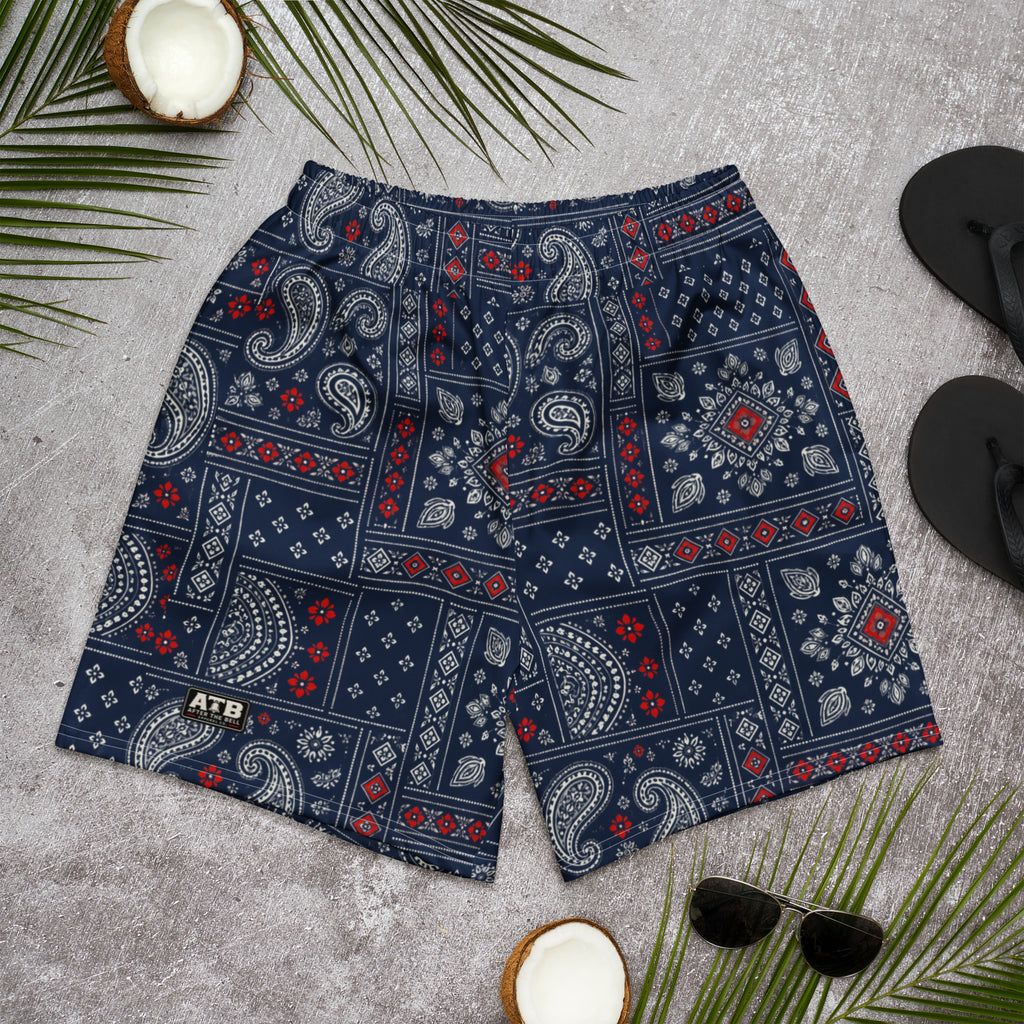 Navy athletic shorts with cream paisley bandana patchwork, red accents, and an ATB leg badge, displayed flat on a gray surface.